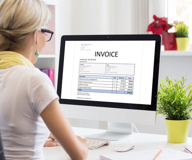 https://www.irisbusiness.com/wp-content/uploads/2024/05/woman-office-with-sample-invoice-document-computer-1-640x533.jpg